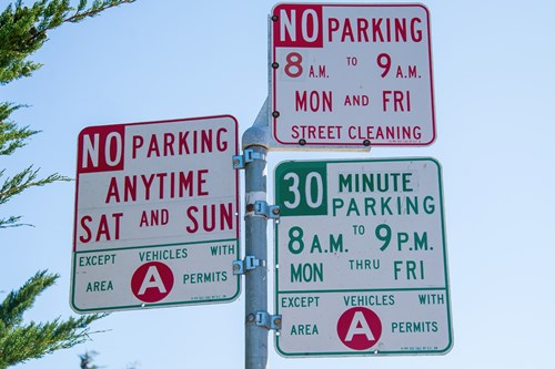 Several parking signs detailing different restrictions