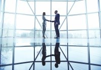 Corporate man and woman shake hands in office building
