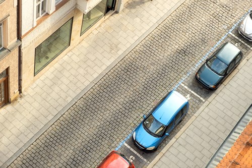 Parallel parked cars on a cobbled city street