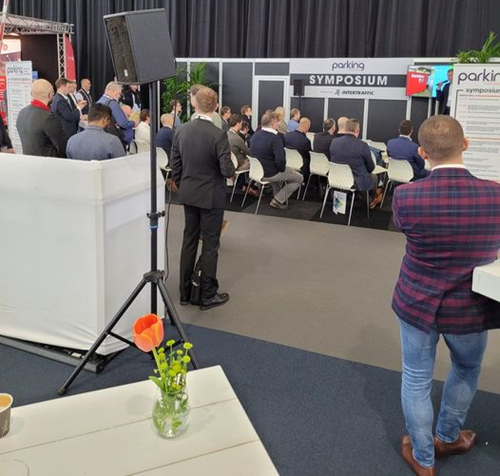 Stage at a tradeshow hall with businessmen and women in the audience