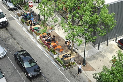 rtist's impression of a sidewalk featuring a parklet with seating and planting