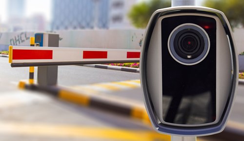 An ANPR camera with a parking barrier in the background