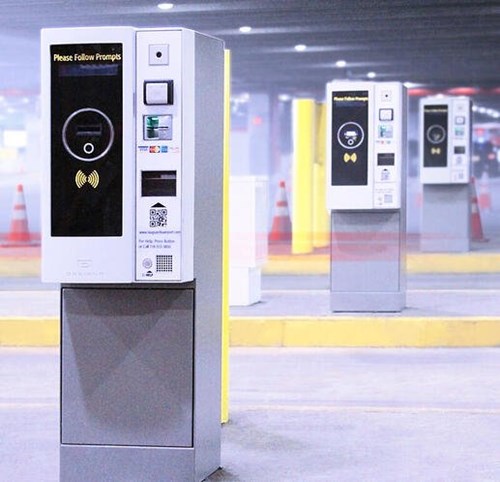 Modern parking meters standing behind each other in the parking garage