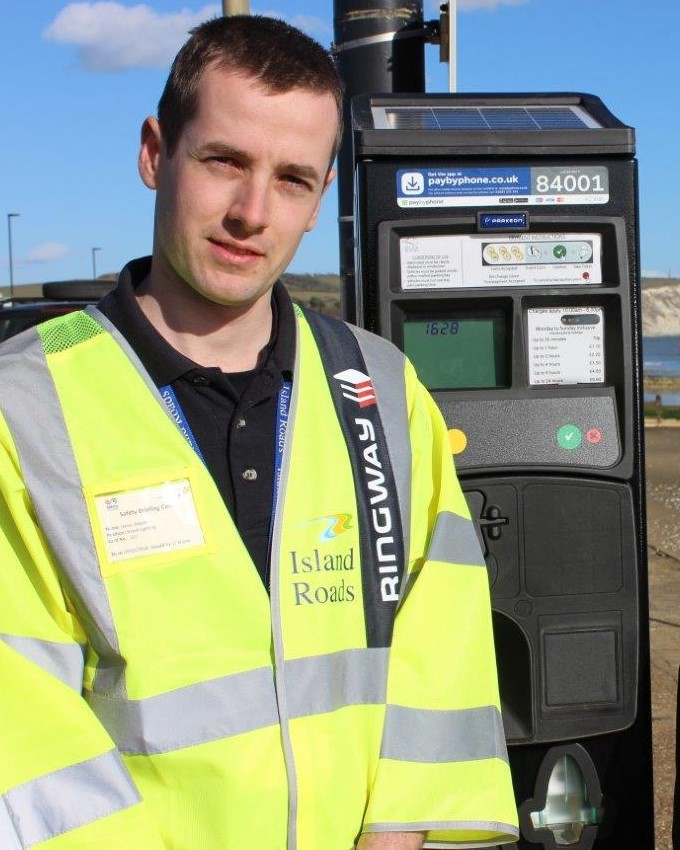 James Adsett stands with one of the new, reliable and efficient solar-powered terminals.