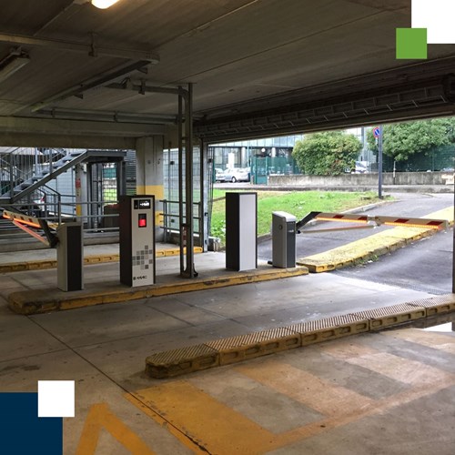 The entrance and exit of a parking garage with barriers