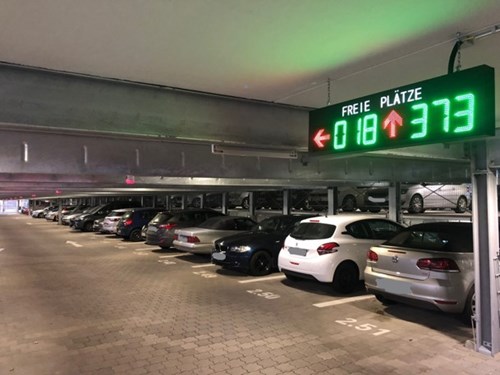 Interior of a parking garage with parking guidance LED signs shows how many spaces are free