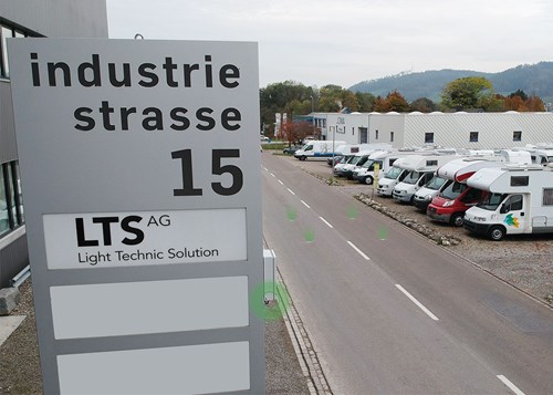Board with address Industriestrasse 15 and LTS AG, parked vehicles in the background