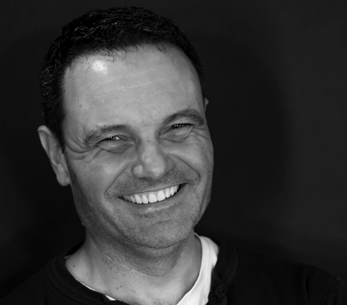 Black and white head shot of smiling business man