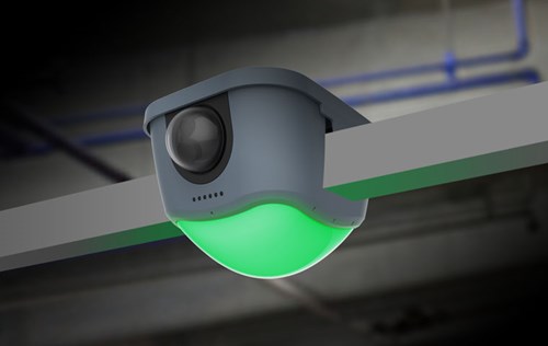 Camera attached to ceiling with green light indicating vacant parking space.