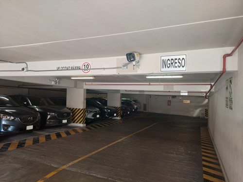 Interior of a parking garage showing an LPR camera and entrance sign.