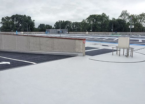 Parking ramp leading to rooftop with trees in the background