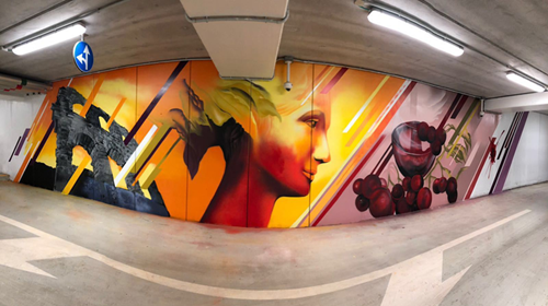 Street art in parking garage, roman ruins, woman's face and glass of wine.