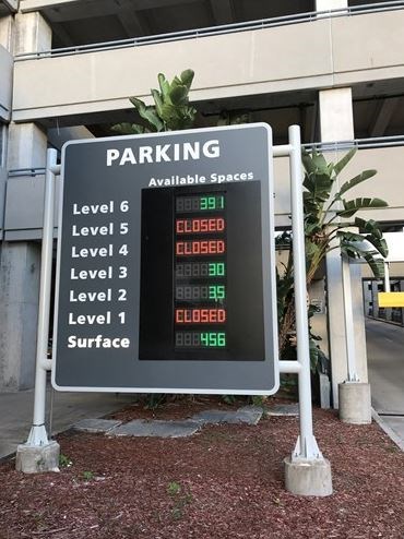 Digital side by entrance to parking garage informing drivers how many spaces there are per level.
