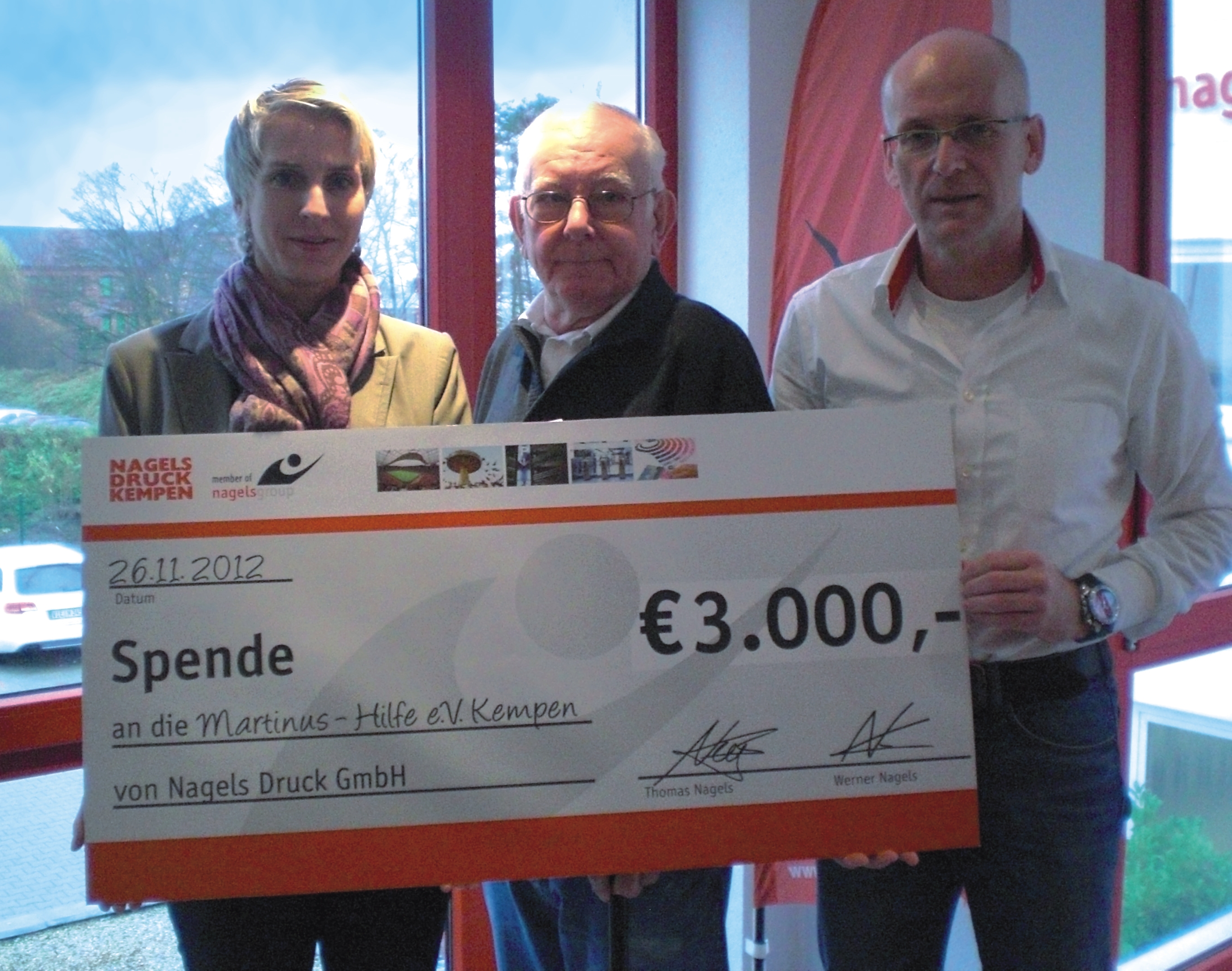 Managing Director (Werner Nagels right) and the groups Marketing Manager Andrea Kamps-de Bruin (left) present a donation cheque to Dieter Sandmann (middle), Chairman of the Board of Martinus – Hilfe e.V.