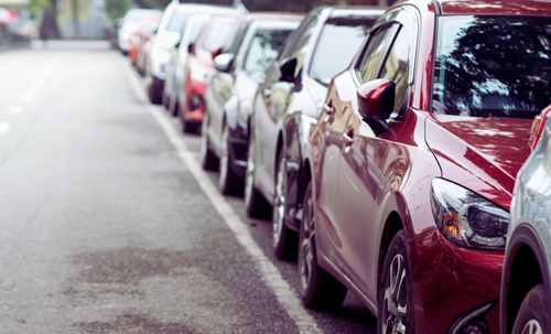 Cars parked in a row on a street.